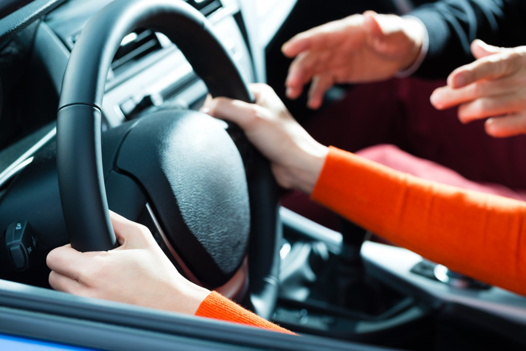 woman holding the car's steering wheel with help